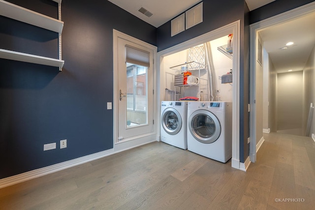 washroom featuring hardwood / wood-style flooring and washing machine and clothes dryer