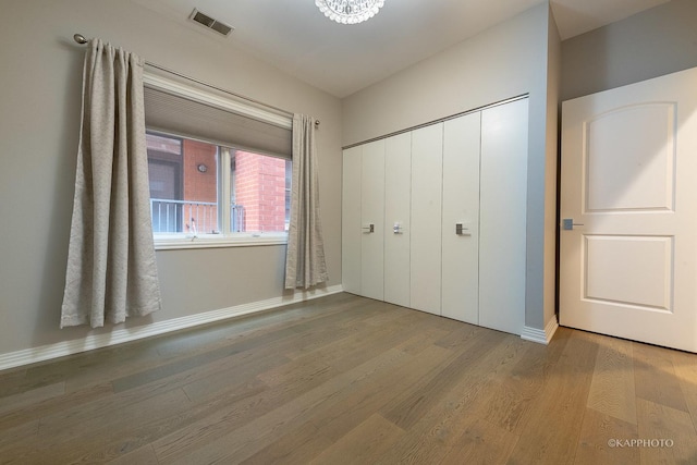 unfurnished bedroom with hardwood / wood-style flooring and a closet