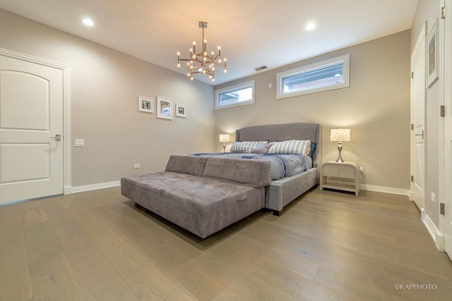 bedroom featuring an inviting chandelier and wood-type flooring