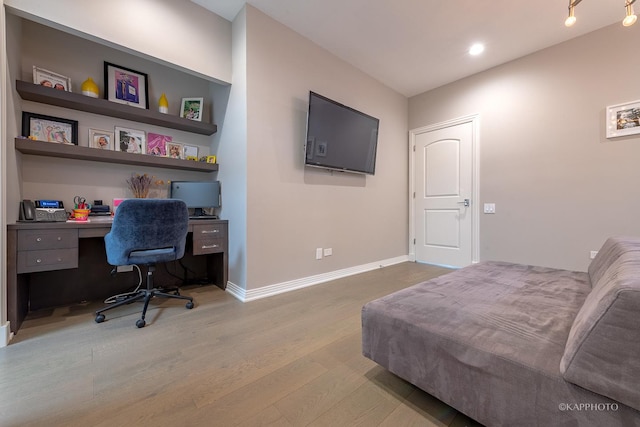 bedroom featuring built in desk and light hardwood / wood-style floors