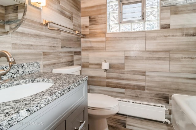 bathroom with a baseboard radiator, tile walls, vanity, and toilet