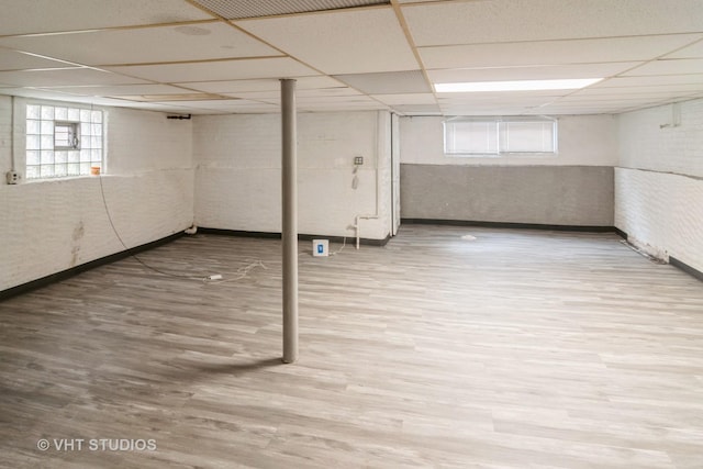 basement featuring hardwood / wood-style flooring and a paneled ceiling