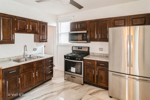 kitchen with appliances with stainless steel finishes, sink, backsplash, ceiling fan, and dark brown cabinets