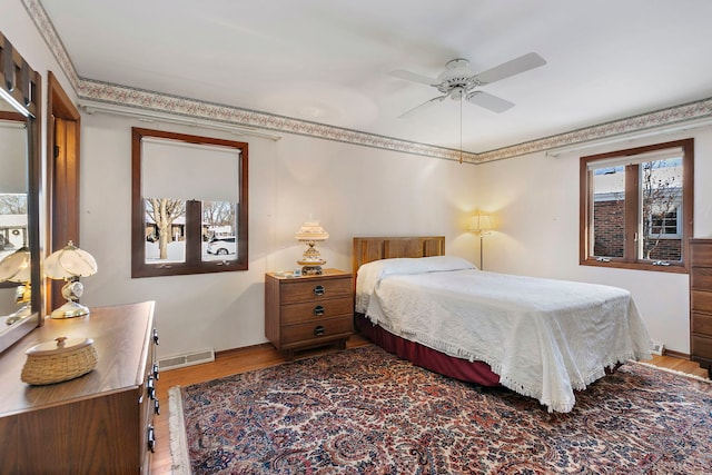 bedroom featuring multiple windows, wood finished floors, and visible vents