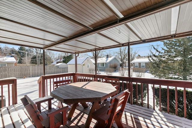 snow covered deck featuring a residential view, fence, and outdoor dining space