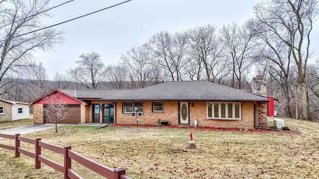 ranch-style home with central AC, a garage, and a front yard