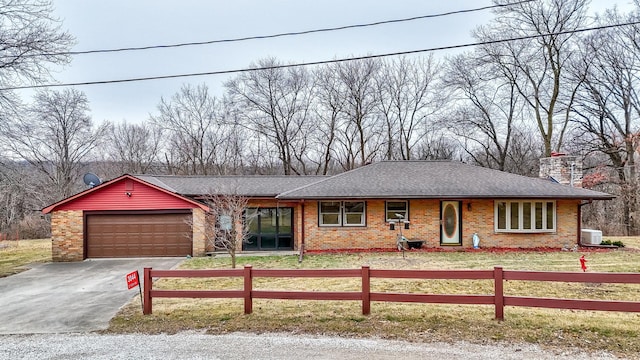 ranch-style home with a garage and a front lawn