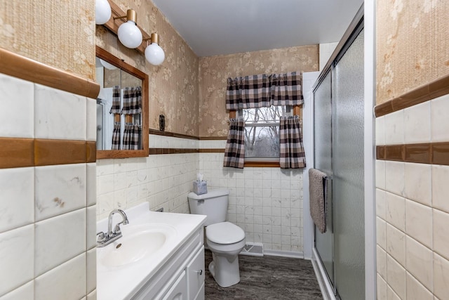 bathroom with vanity, an enclosed shower, hardwood / wood-style flooring, and tile walls