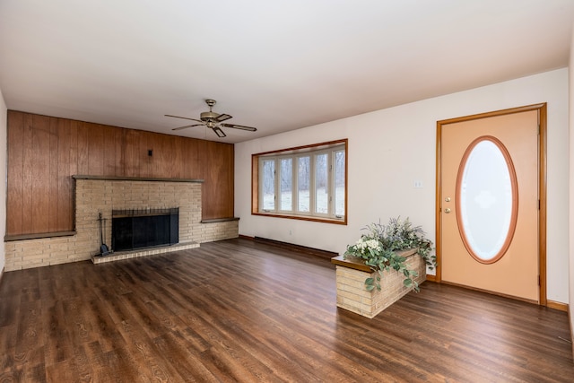 foyer entrance featuring ceiling fan, dark hardwood / wood-style floors, and a fireplace