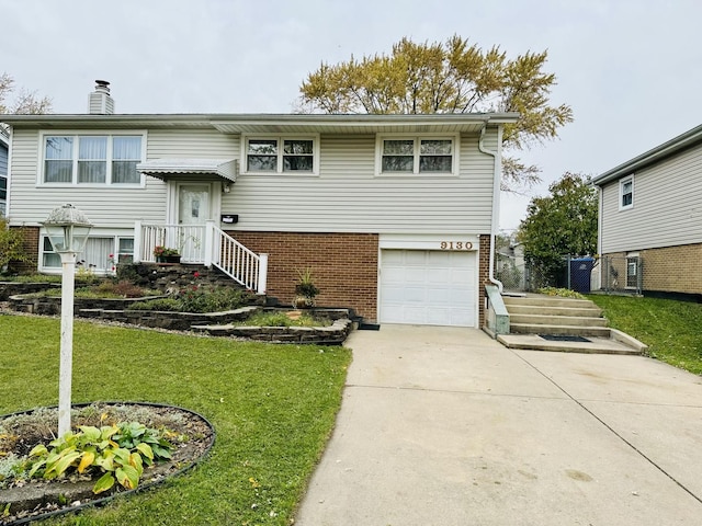 raised ranch with a garage and a front lawn