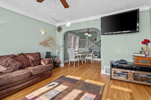 living room with crown molding, hardwood / wood-style floors, a textured ceiling, and ceiling fan