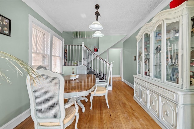 dining space featuring light hardwood / wood-style floors and a textured ceiling