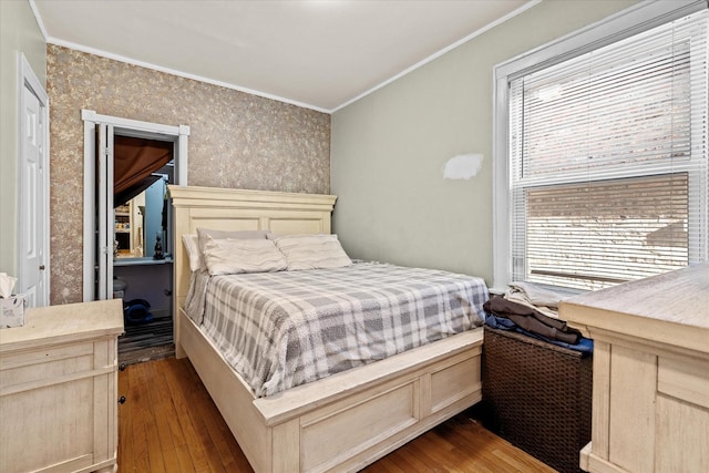 bedroom with crown molding and hardwood / wood-style flooring