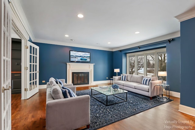 living room featuring french doors, crown molding, a glass covered fireplace, wood finished floors, and baseboards