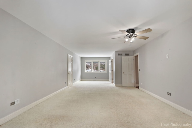 unfurnished room with light carpet, visible vents, baseboards, and a ceiling fan