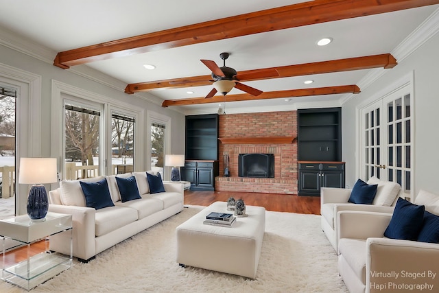 living area featuring crown molding, recessed lighting, a brick fireplace, wood finished floors, and beamed ceiling