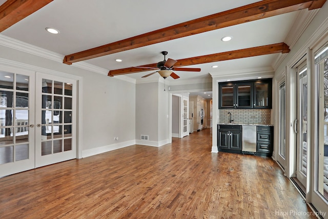 unfurnished living room with french doors, beamed ceiling, wood finished floors, and visible vents