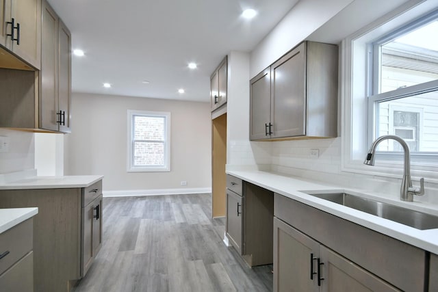 kitchen featuring sink, decorative backsplash, and light hardwood / wood-style floors