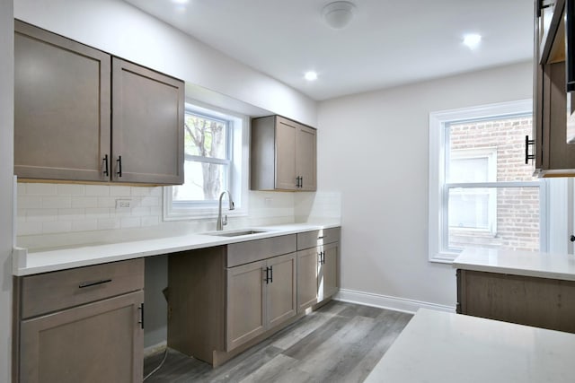 kitchen with sink, light hardwood / wood-style floors, and decorative backsplash