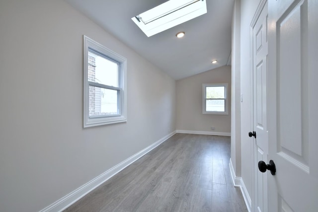 bonus room featuring light hardwood / wood-style flooring and vaulted ceiling with skylight