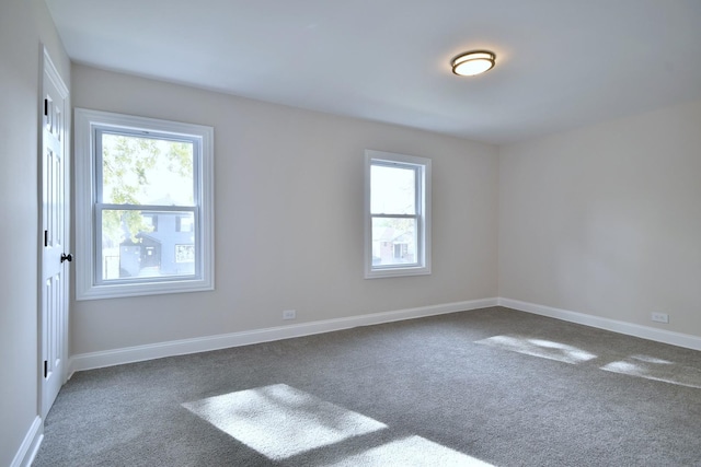 spare room featuring dark colored carpet