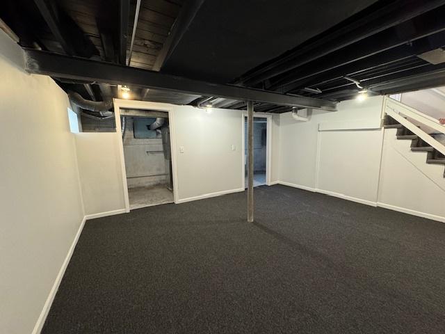 basement with dark colored carpet