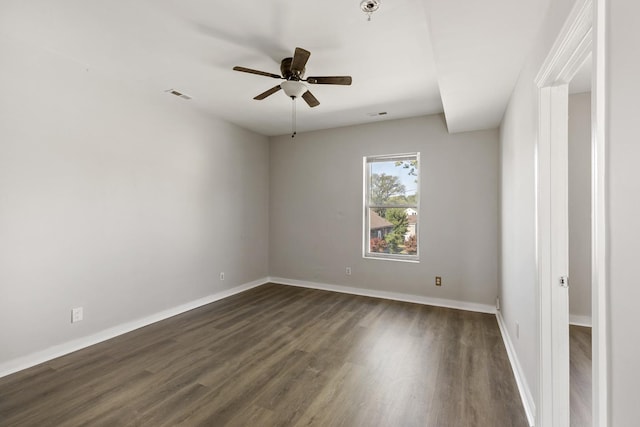 spare room with dark wood-type flooring and ceiling fan