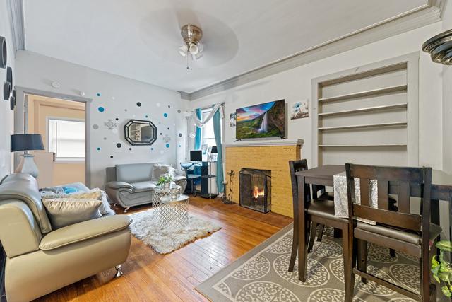 living room with wood-type flooring and ceiling fan