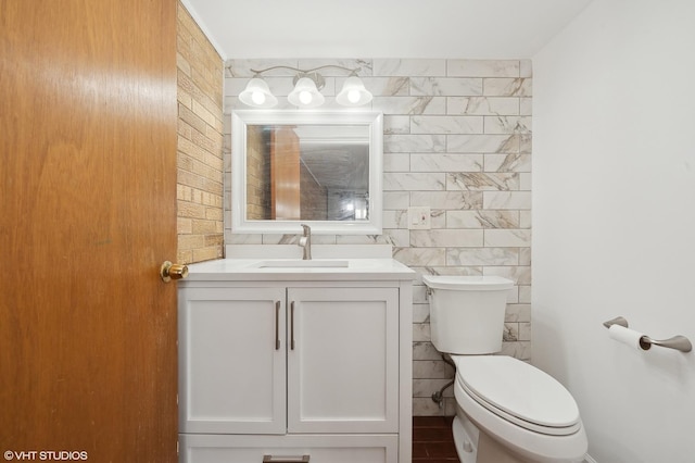 bathroom featuring vanity, toilet, and tile walls