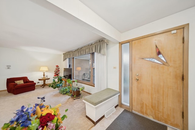 foyer featuring light carpet