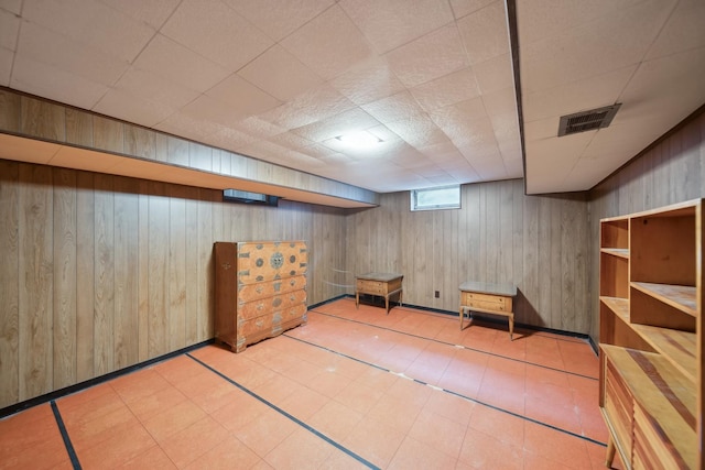 basement featuring wood walls