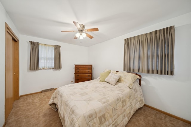 bedroom featuring light carpet, a closet, and ceiling fan