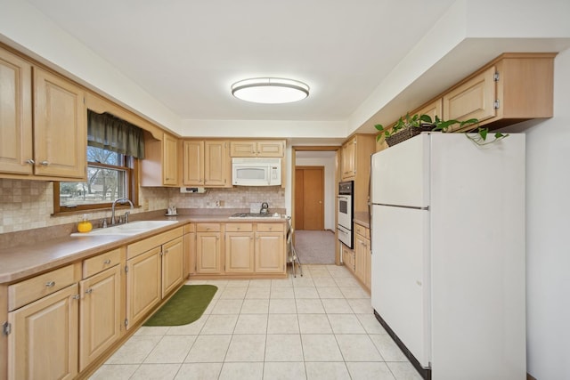 kitchen with white appliances, sink, decorative backsplash, and light brown cabinets