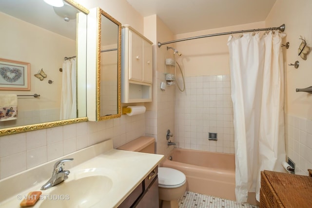 full bathroom with tile walls, vanity, toilet, and shower / tub combo with curtain