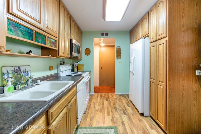 kitchen with white appliances, sink, and light wood-type flooring