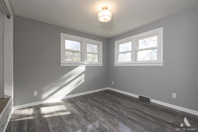 unfurnished room with dark wood-type flooring