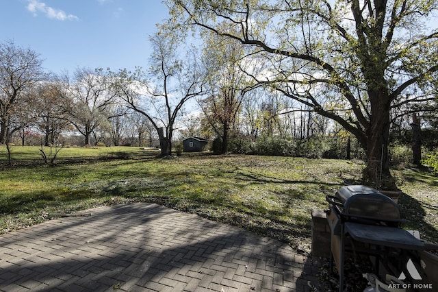 wooden terrace featuring a grill, a patio area, and a lawn