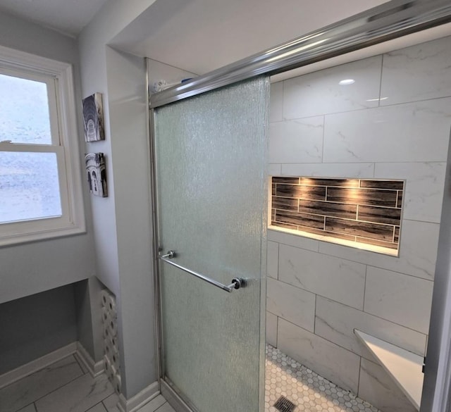 bathroom featuring a shower with door