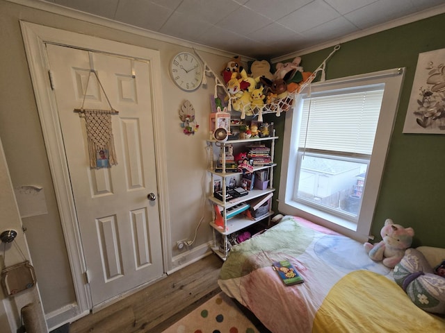 bedroom with crown molding and hardwood / wood-style flooring