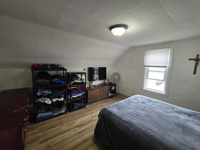 bedroom featuring wood-type flooring and vaulted ceiling