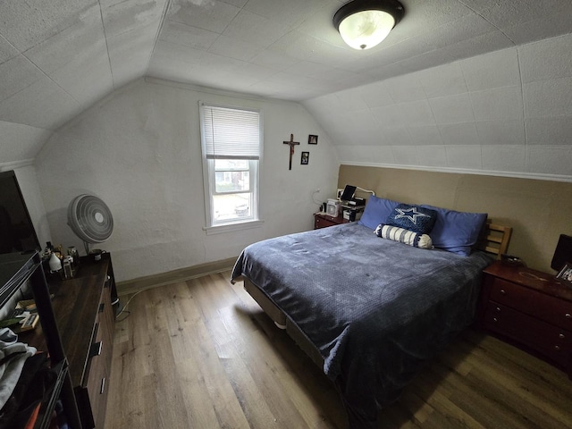 bedroom featuring hardwood / wood-style flooring and vaulted ceiling