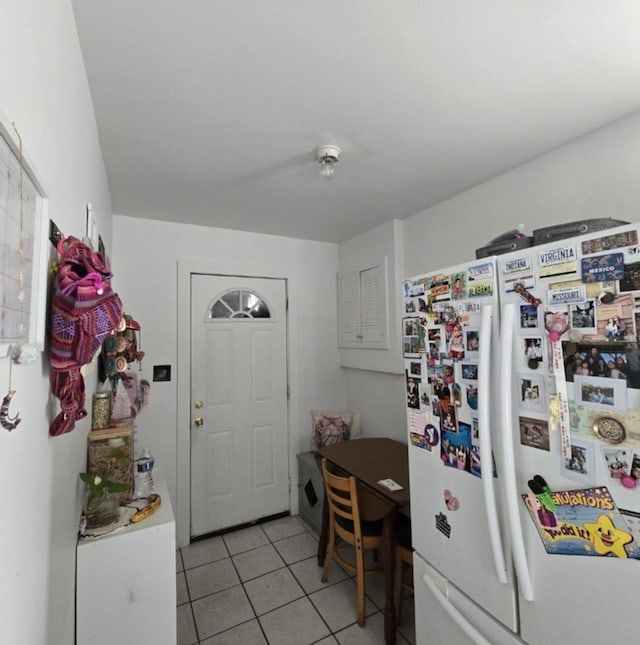 kitchen with light tile patterned flooring and white fridge