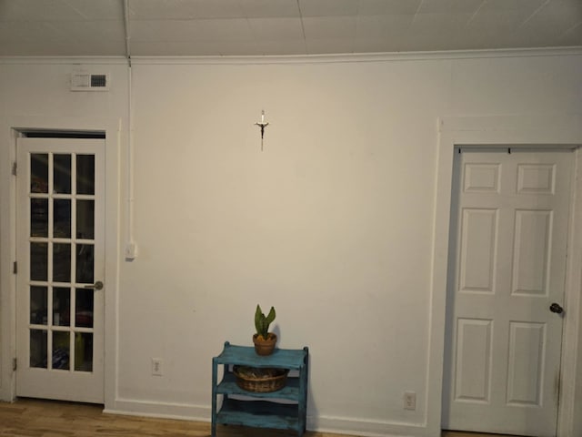 interior space featuring wood-type flooring and ornamental molding