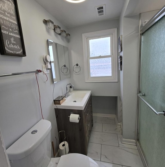 bathroom with a shower with door, vanity, and toilet