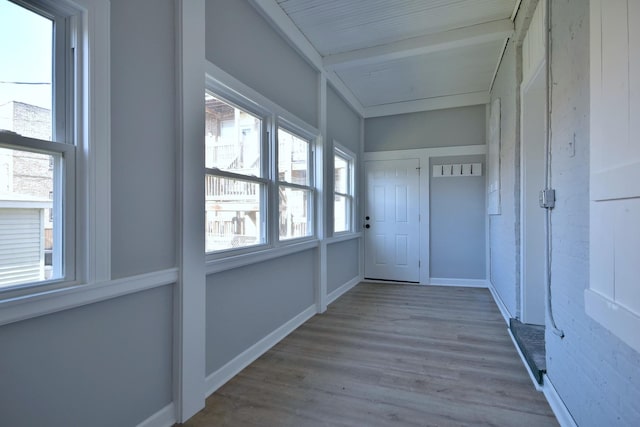 hall featuring hardwood / wood-style flooring and beamed ceiling