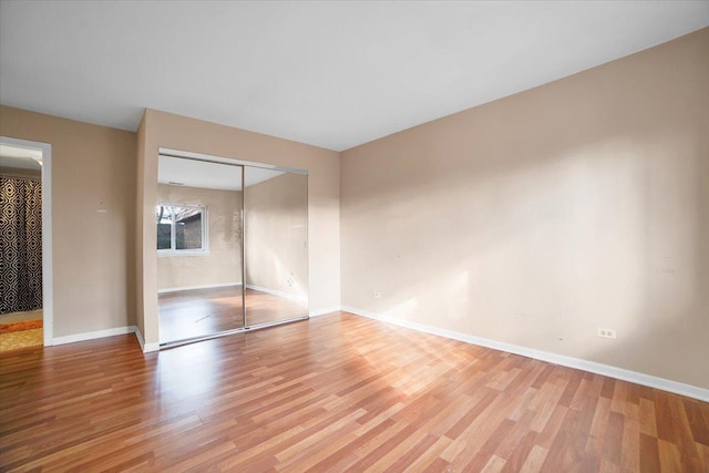 unfurnished bedroom with a closet and light hardwood / wood-style flooring