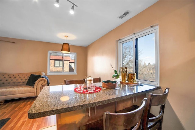 dining room with wood-type flooring and rail lighting