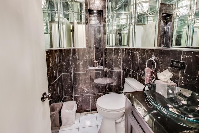 bathroom with tile patterned flooring, vanity, tile walls, and toilet