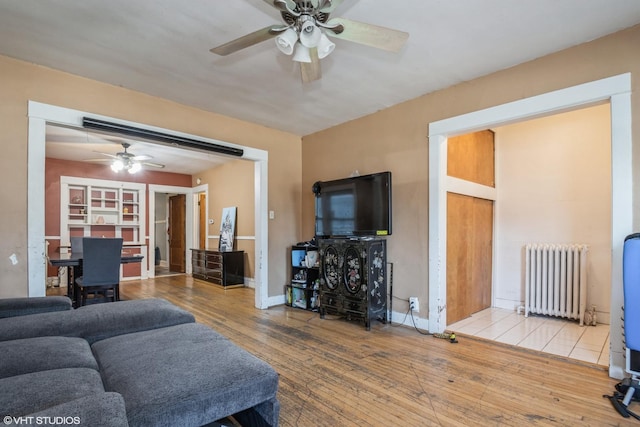 living room featuring ceiling fan, radiator heating unit, and light hardwood / wood-style floors