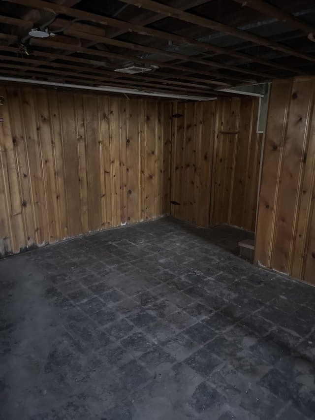 basement featuring wood walls